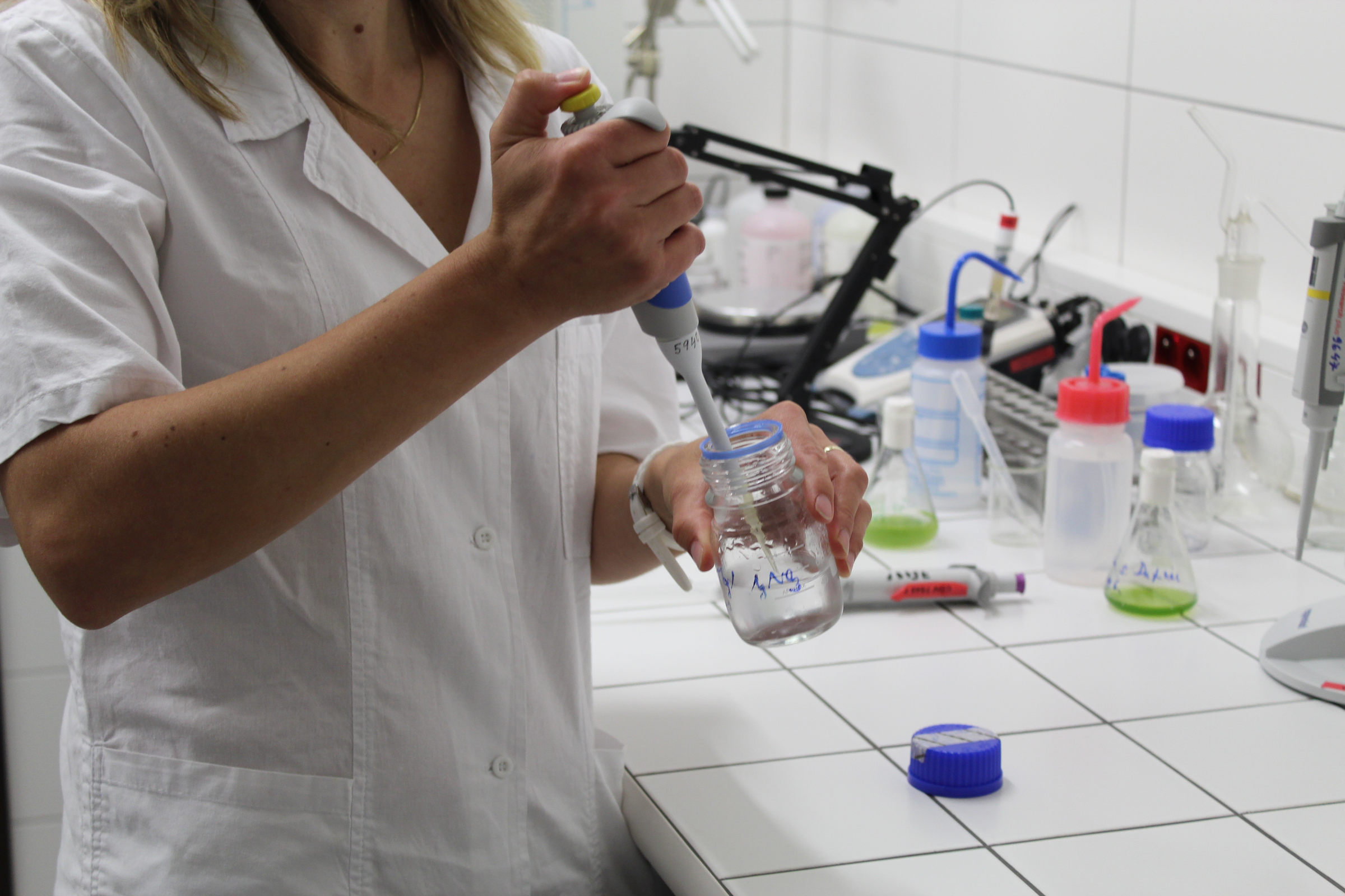 Žena dávkuje chemikálii do zkumavky