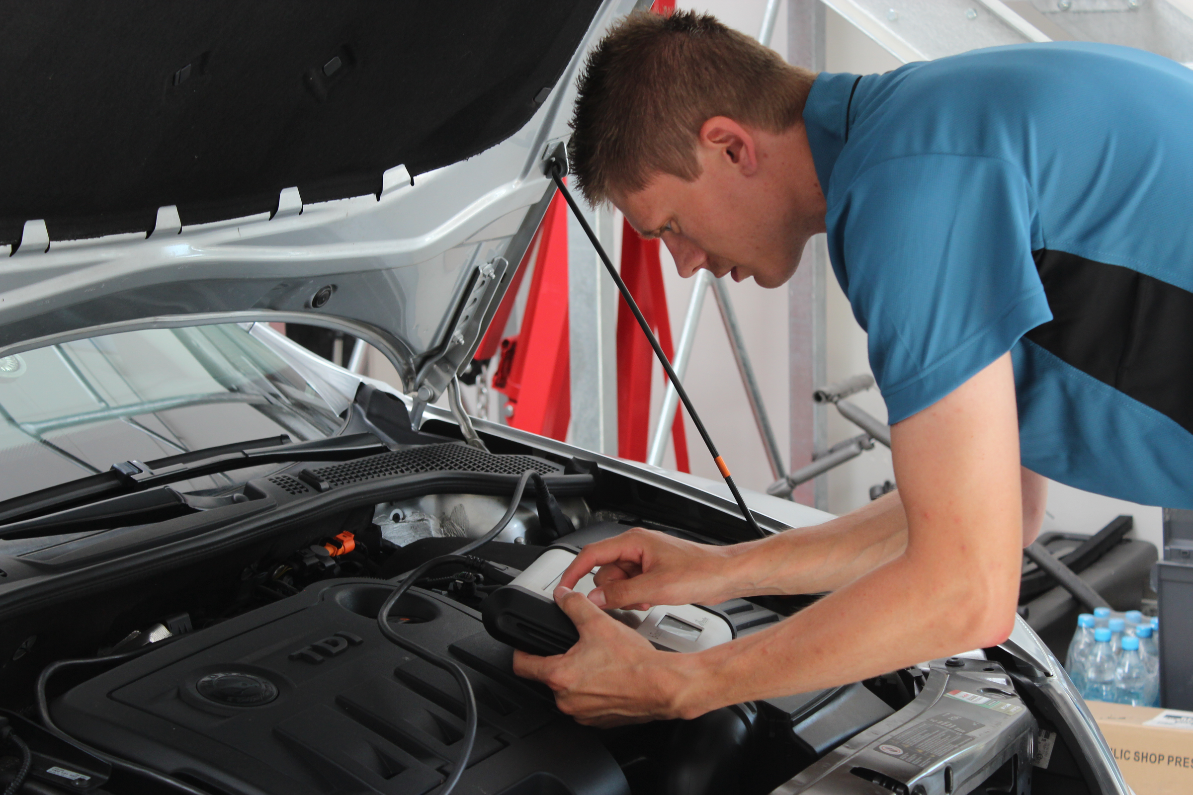 Muž zkoumá motor vozidla